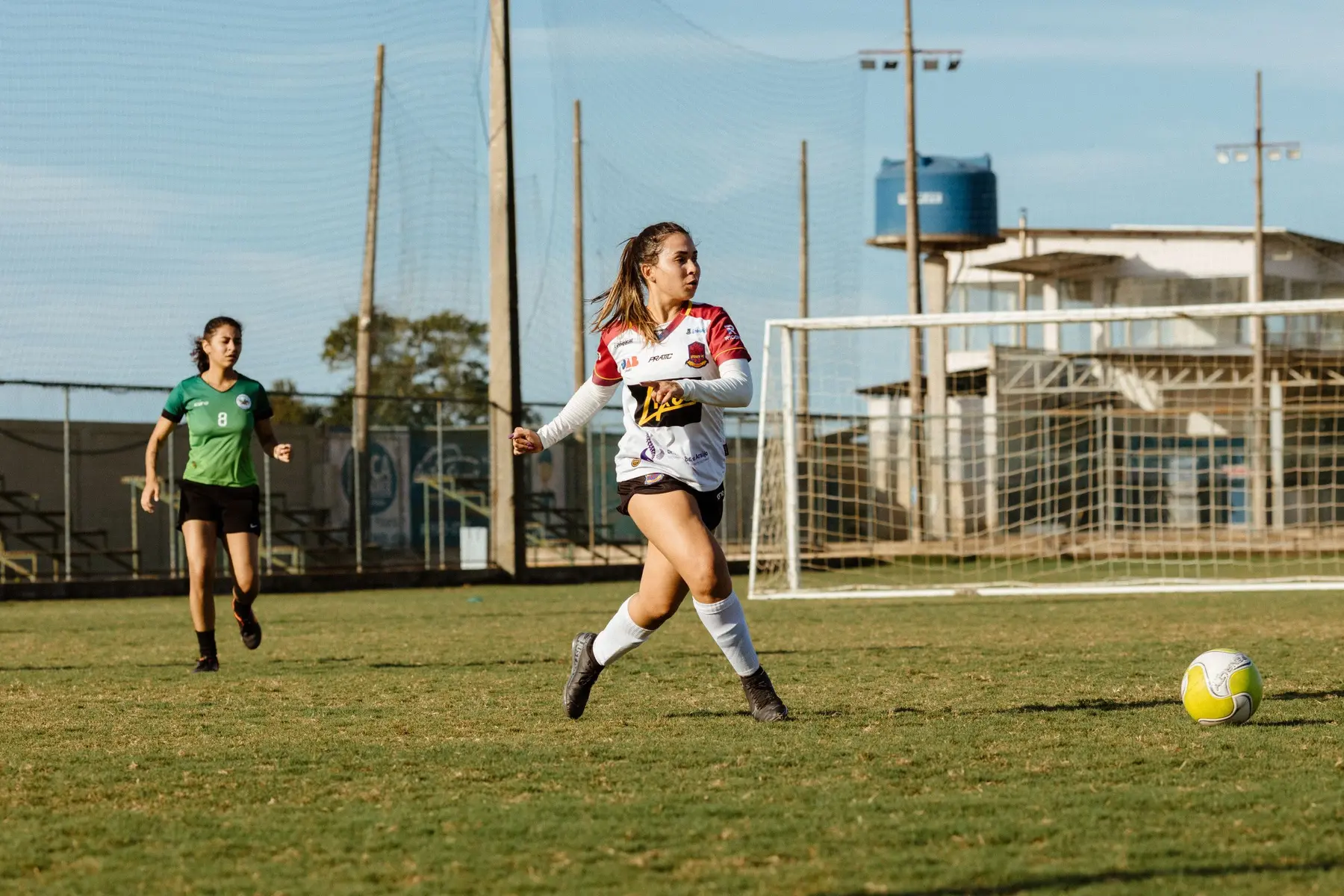 Women competing for the ball during an outdoor soccer match